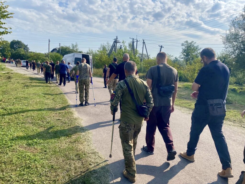 Група людей, включно з військовими, йде вулицею