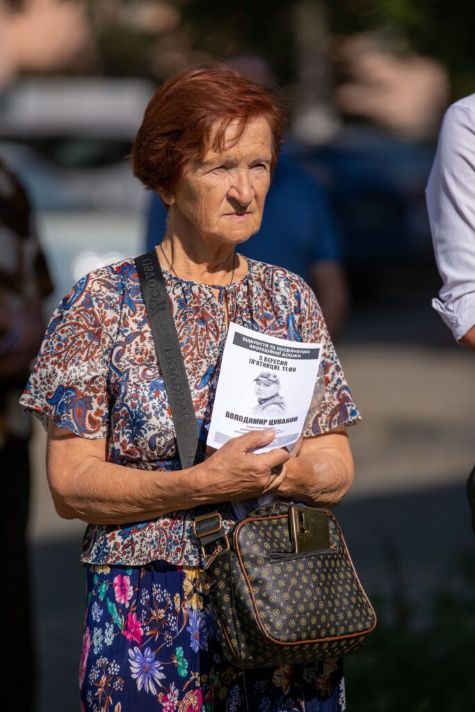 Жінка тримає програму заходу на відкритому повітрі.