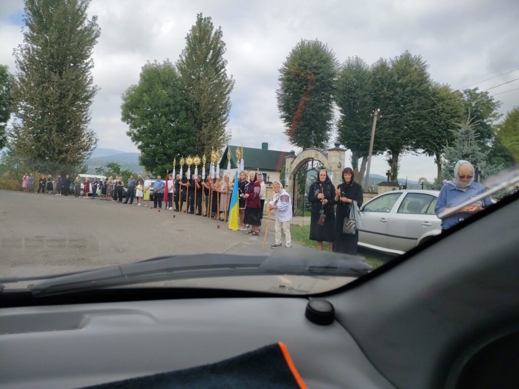 Люди зібрались на вулиці біля церкви.