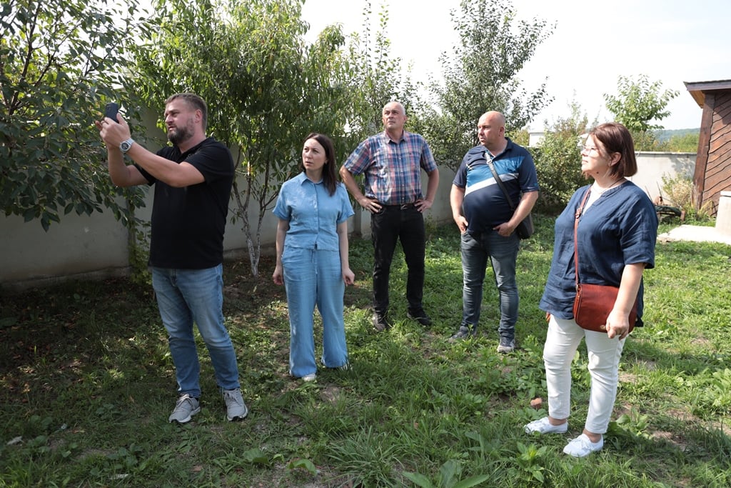 Група людей спостерігає за природою в саду.