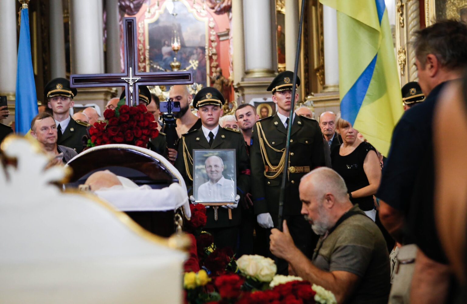 Похоронна церемонія з українськими військовими та прапорами