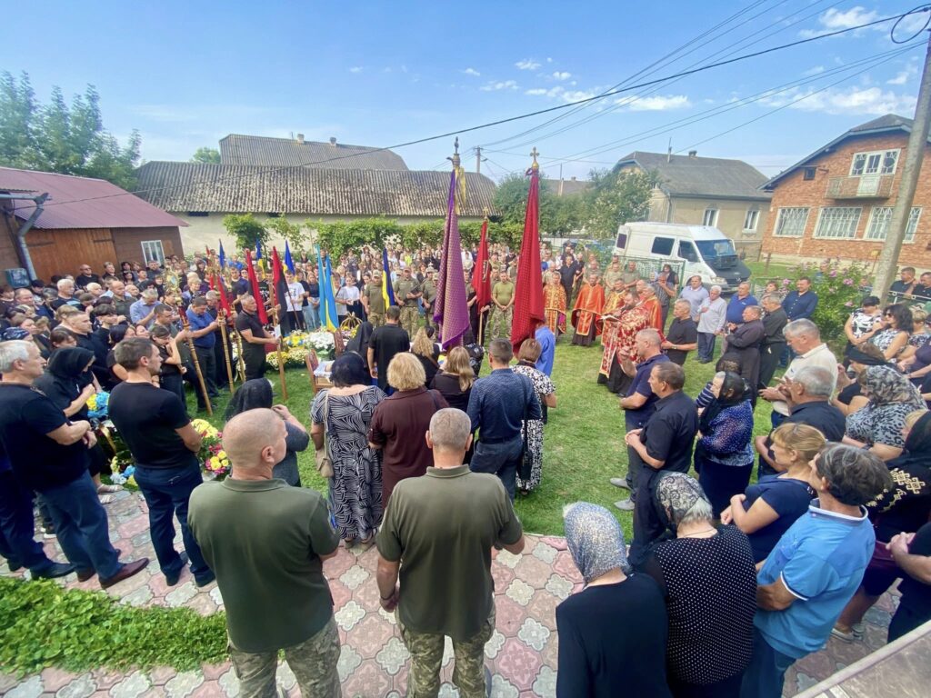 Багато людей на церемонії з прапорами