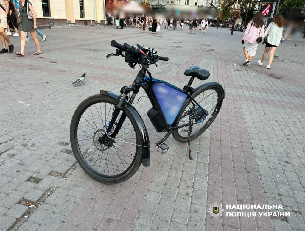 Електровелосипед на пішохідній вулиці, люди навколо.