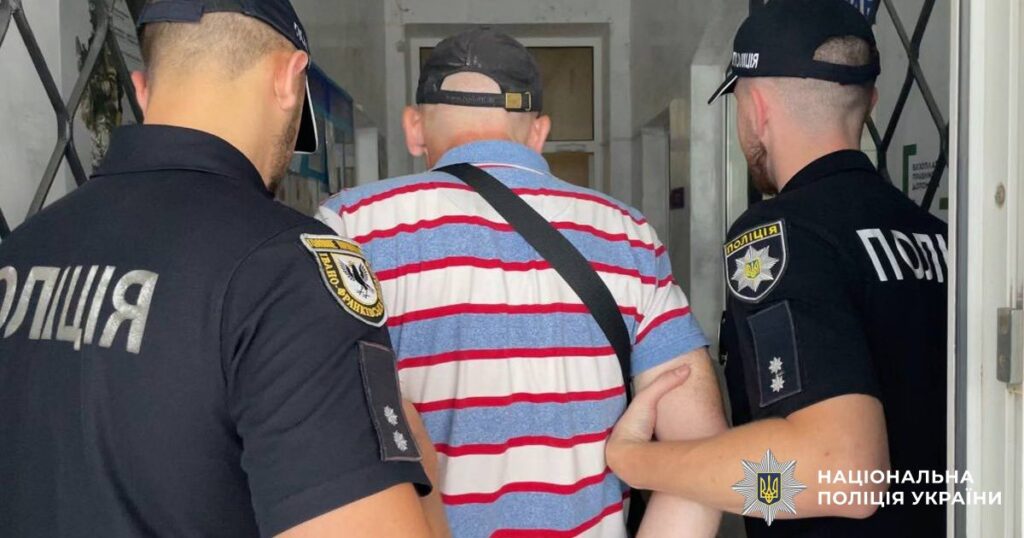 Чоловік у супроводі поліцейських входить в будівлю.