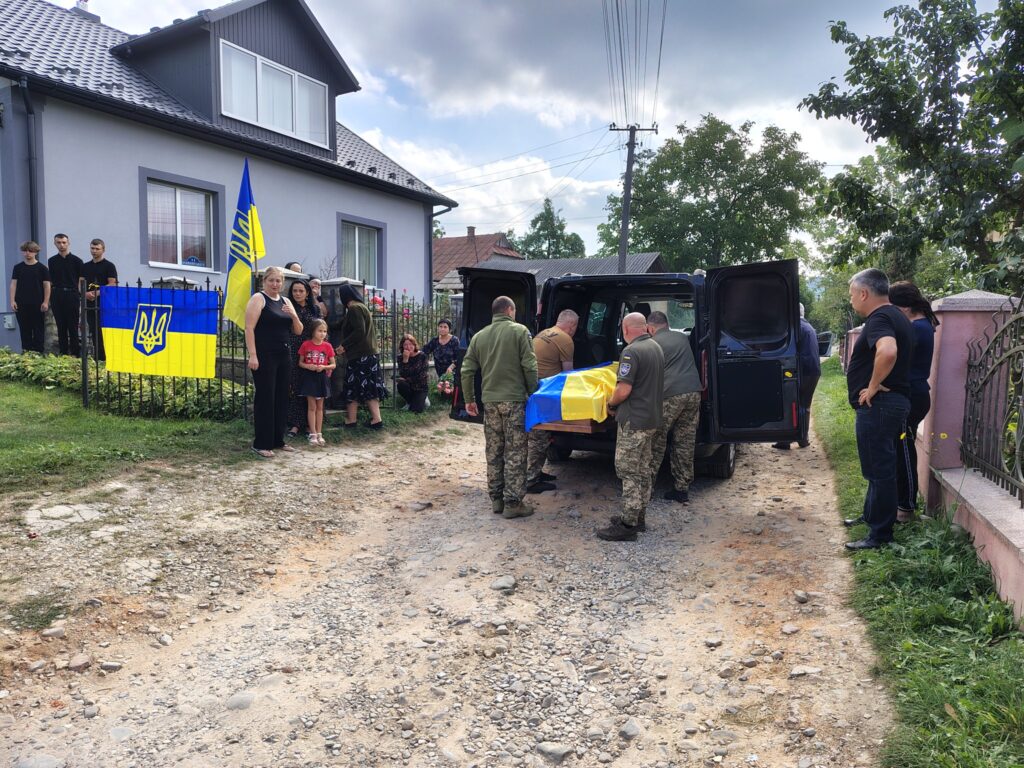 Військові вшанування з українським прапором і людьми