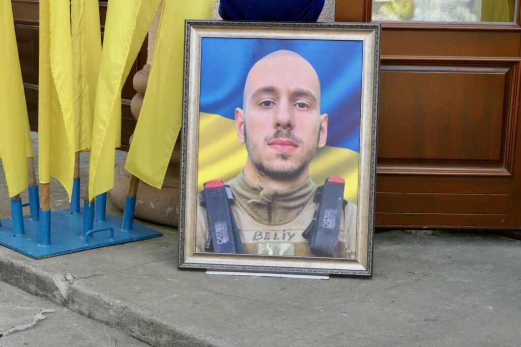 Світлина військового перед прапором України