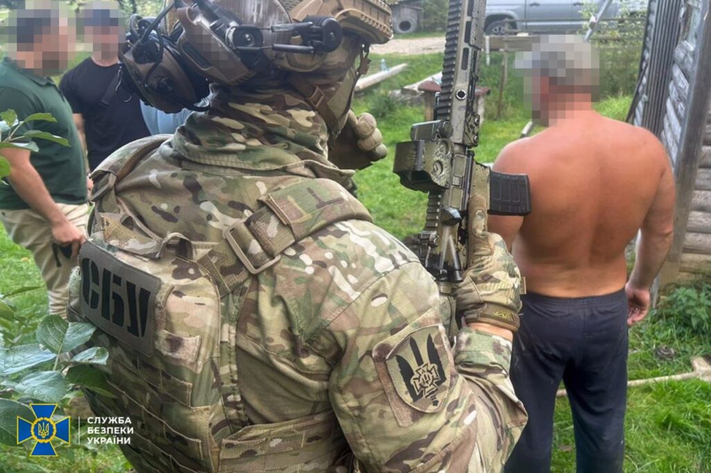 Офіцер СБУ затримує чоловіка на вулиці.