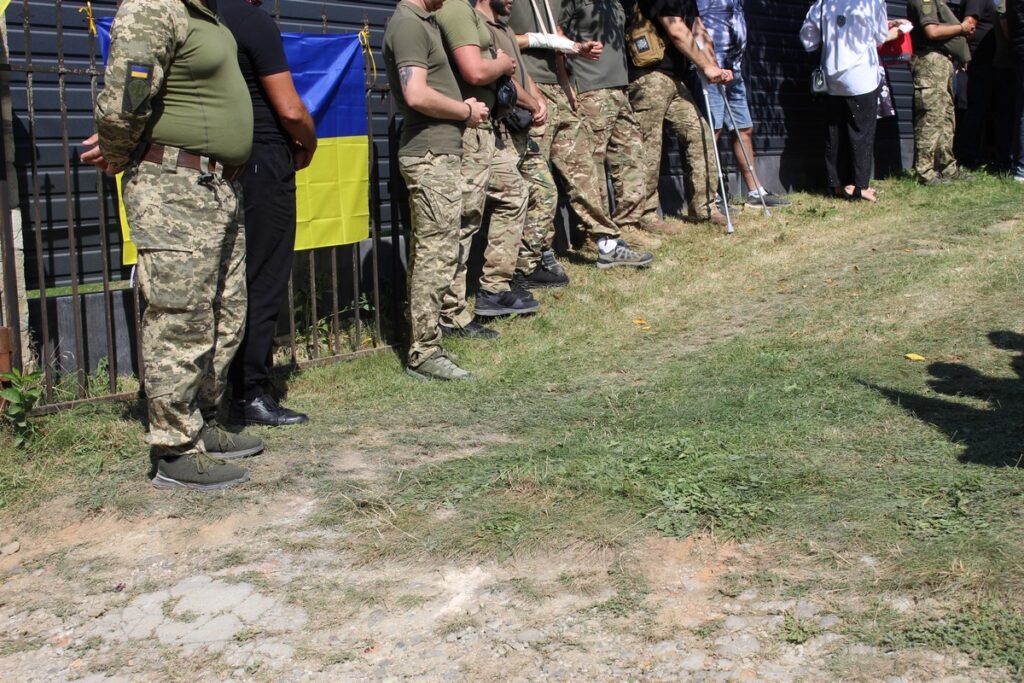 Люди в камуфляжі біля українського прапора