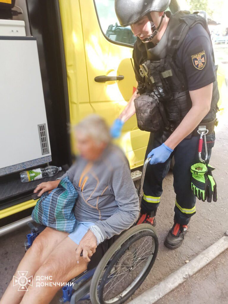 Рятувальник допомагає людині на інвалідному візку