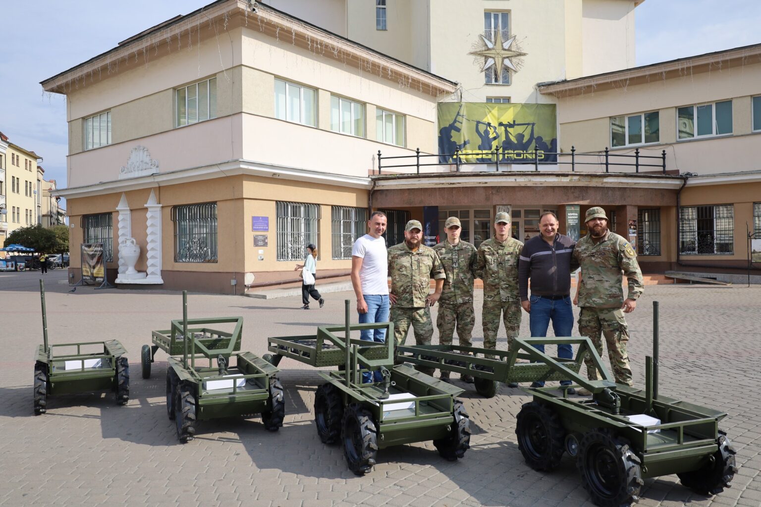 Військові з вантажними візками перед будівлею в Україні.
