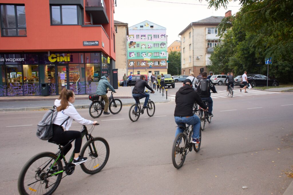 Люди їдуть на велосипедах вулицею міста