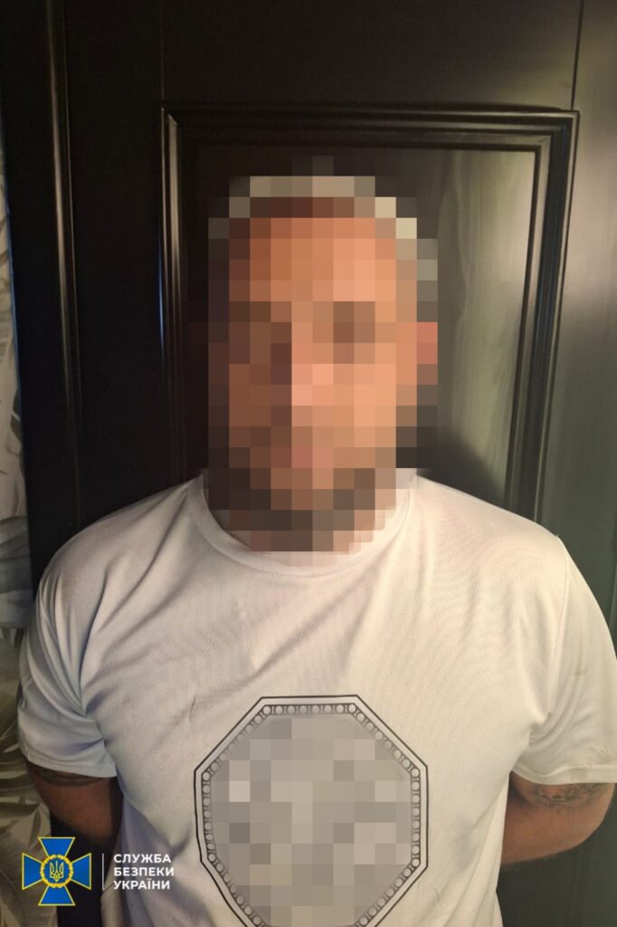 Чоловік у білій футболці, обличчя піксельоване.