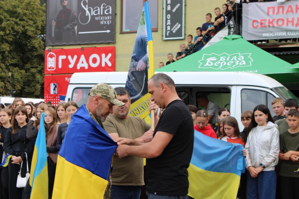 Люди тримають прапори на вуличному заході в Україні.