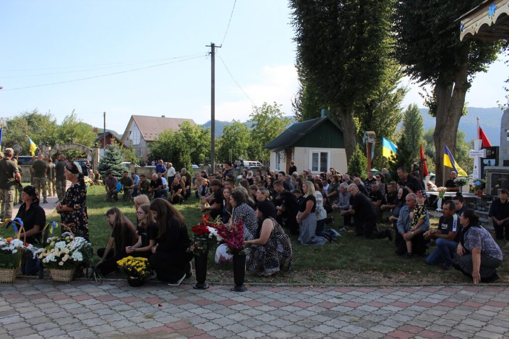 Люди на зібранні з українськими прапорами