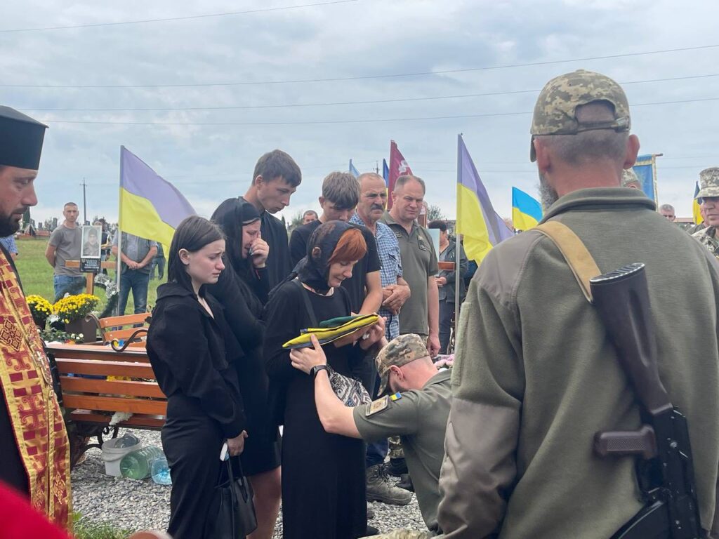 Прощання з військовим під українськими прапорами.