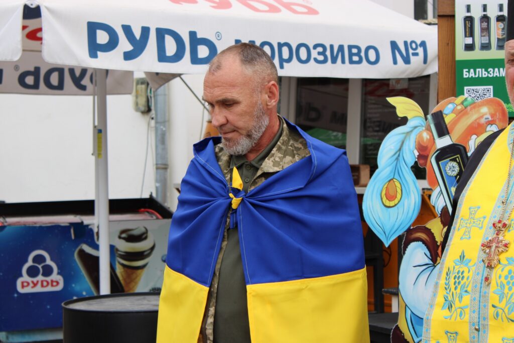 Чоловік у військовій формі з українським прапором