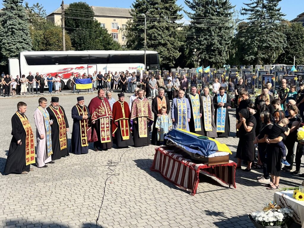 Церемонія вшанування загиблих з прапором України.