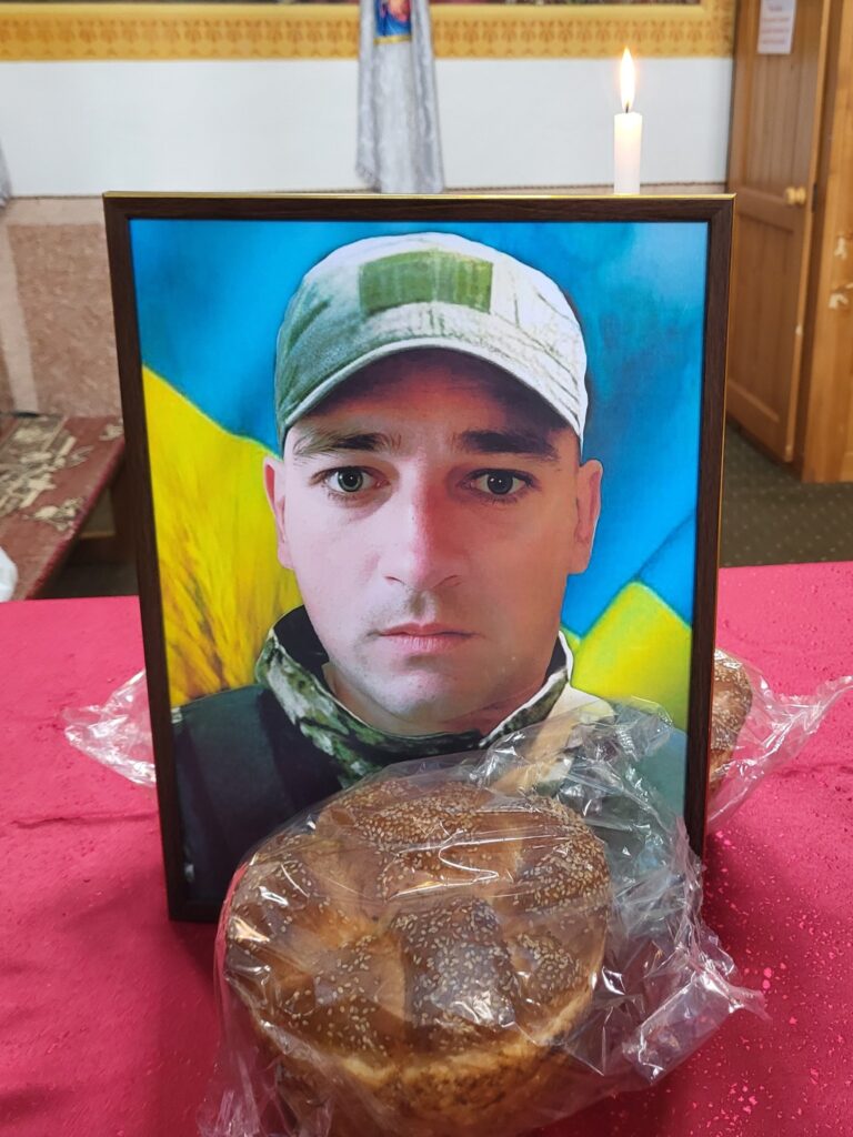 Портрет воїна на столі з хлібом і свічкою.