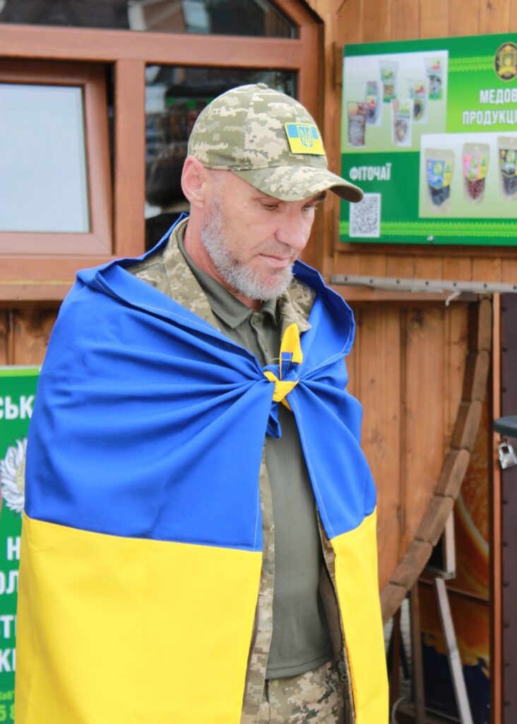 Військовий у формі з прапором України