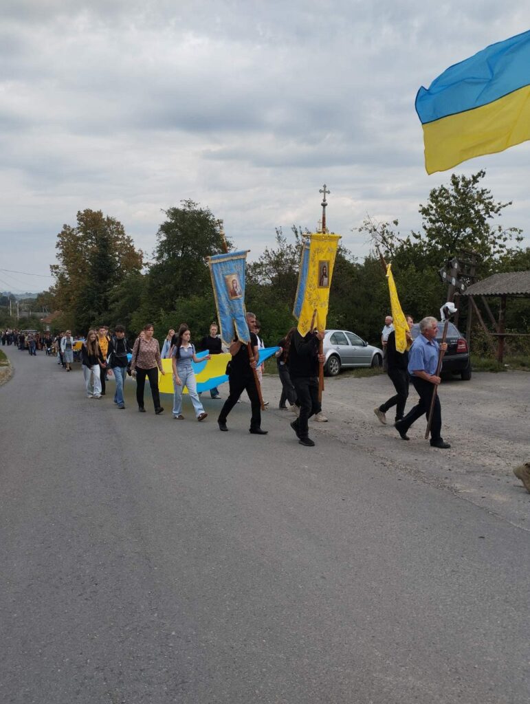 Хода з українським прапором у полі.