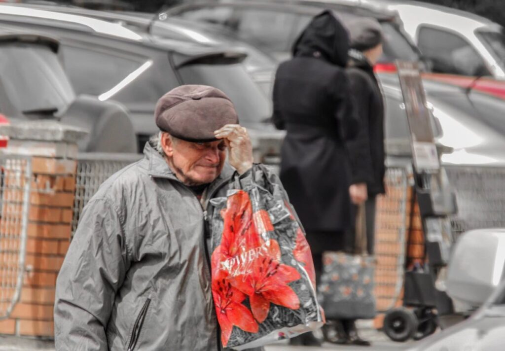 Літній чоловік з пакетом на вулиці