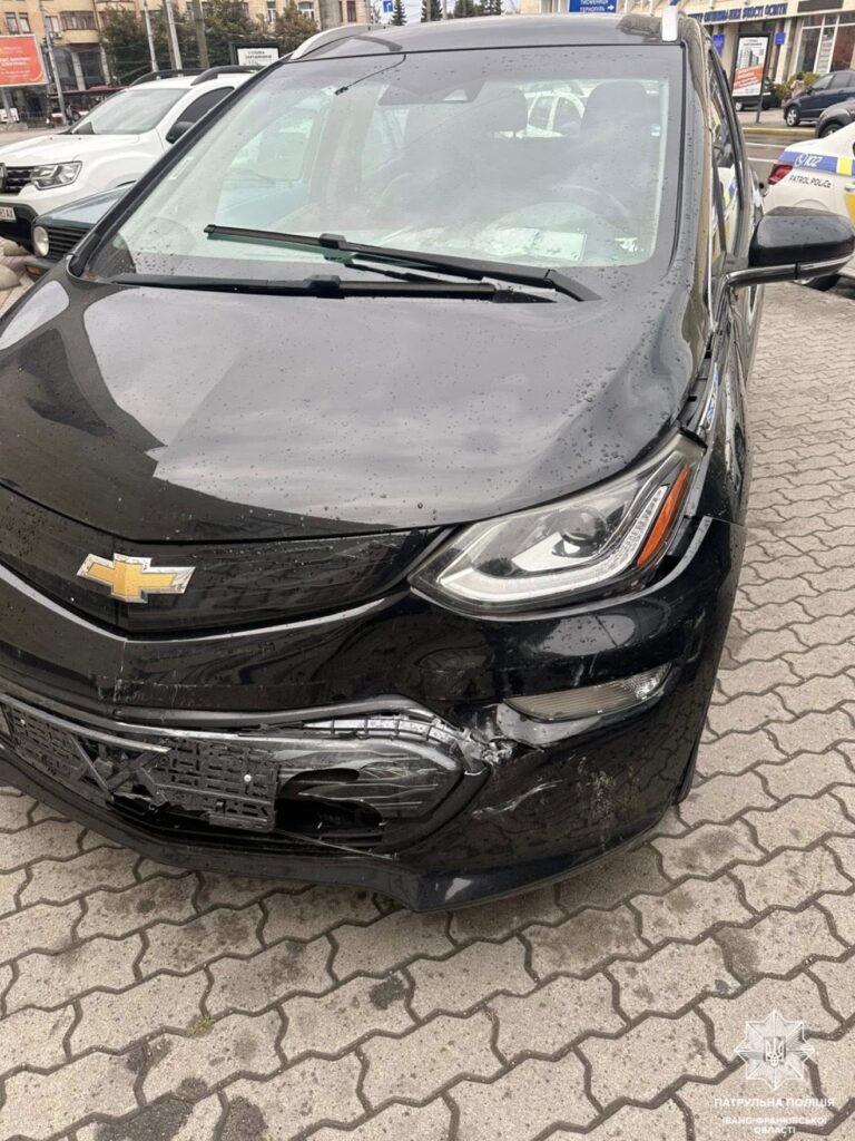 Пошкоджене чорне авто на парковці