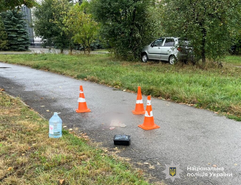 Дорожні конуси на асфальті біля автомобіля.
