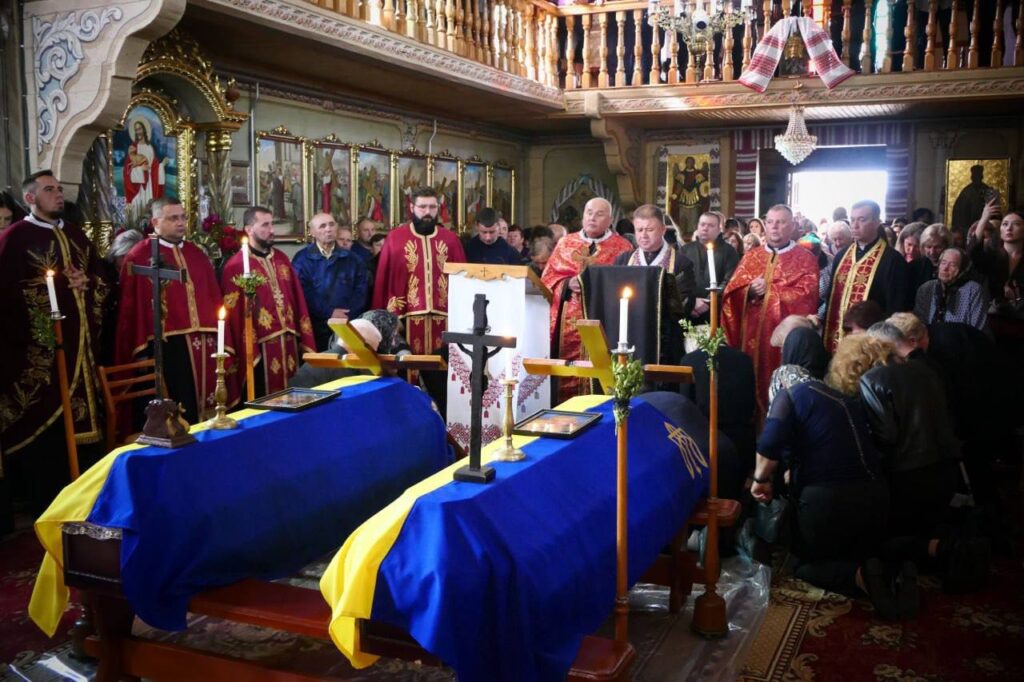 Панахида в церкві з двома трунами під прапорами