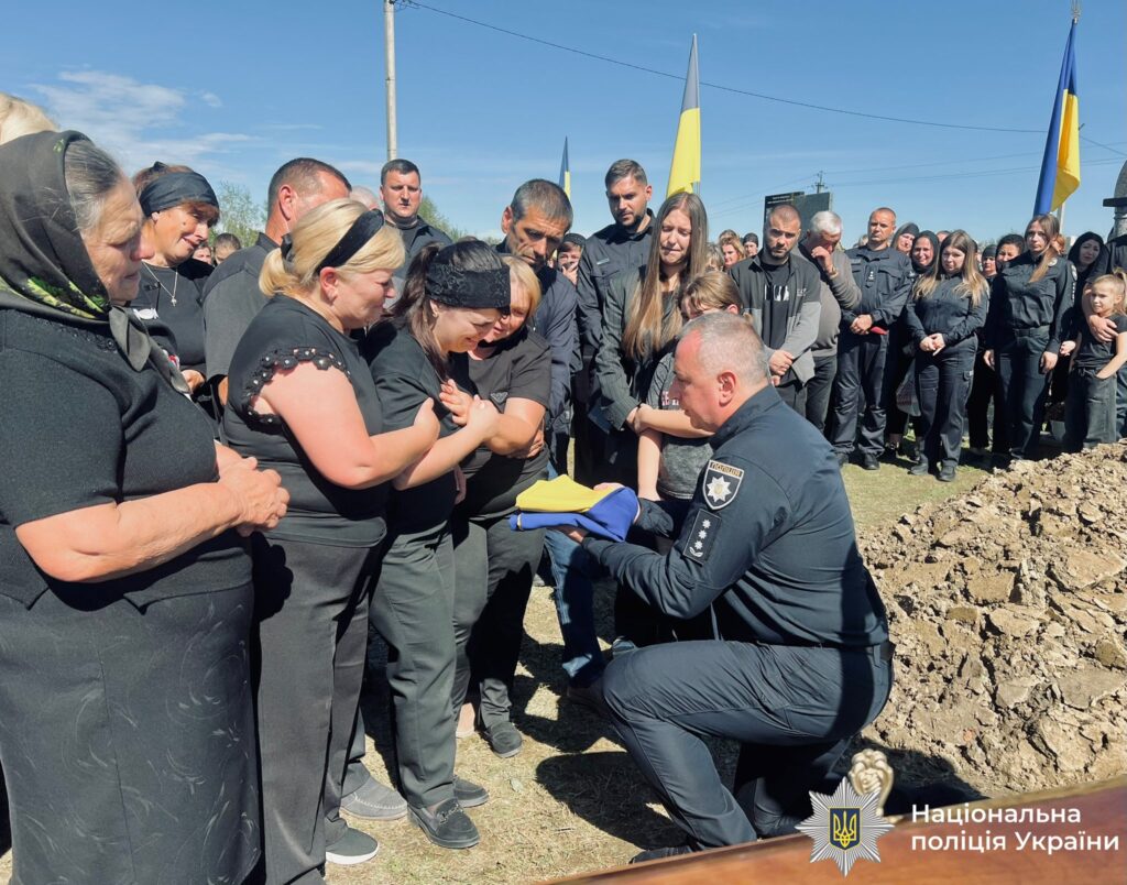 Церемонія прощання з українським прапором, люди в скорботі.