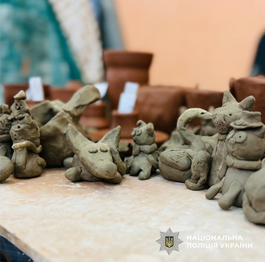 Глиняні фігурки на столі перед горщиками.