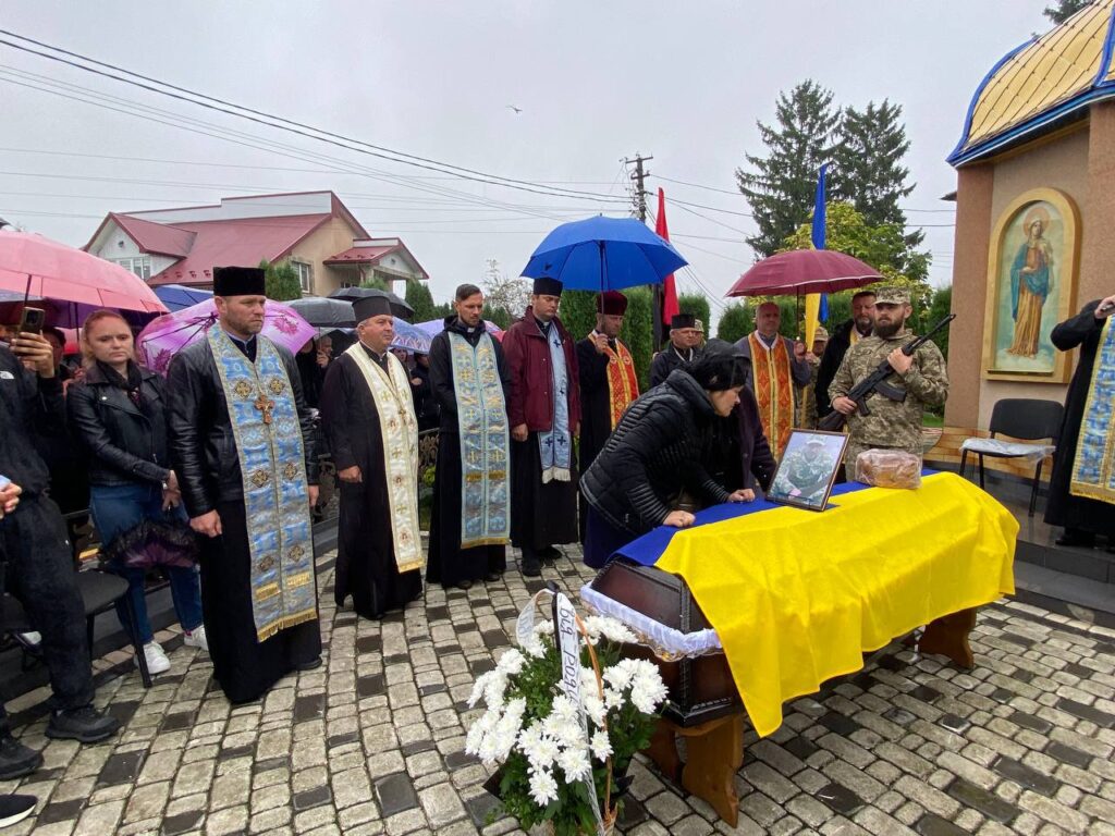 Церковна процесія з жовто-блакитним покривалом та військовим.