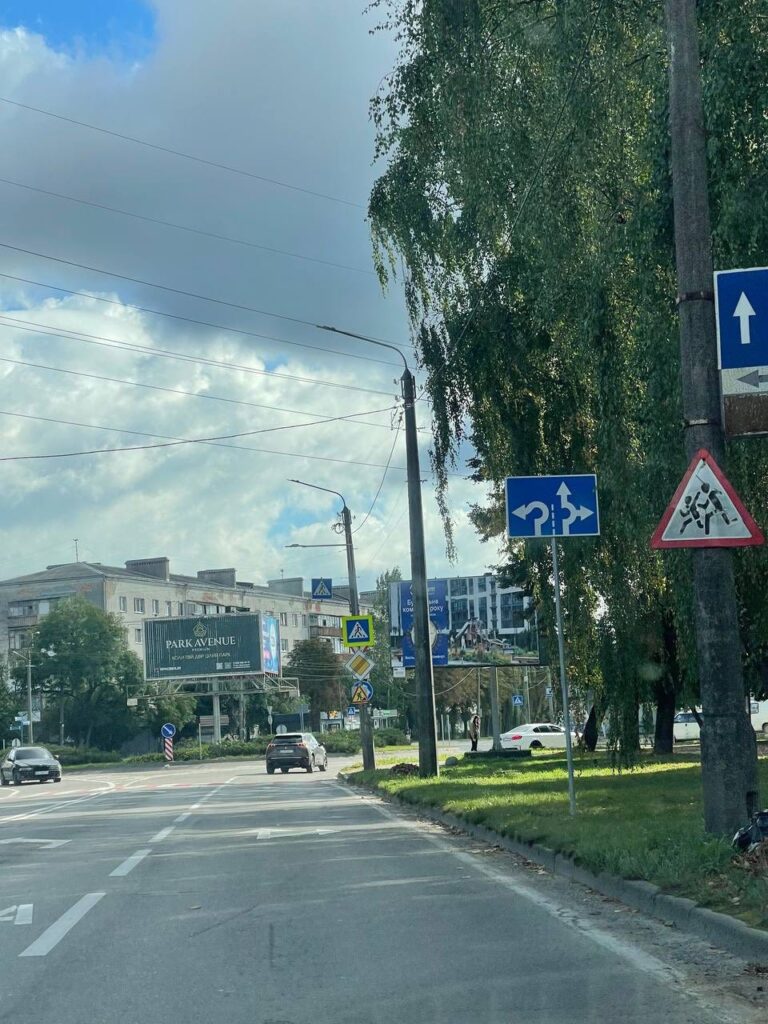 Дорожні знаки на міській вулиці з автомобілями