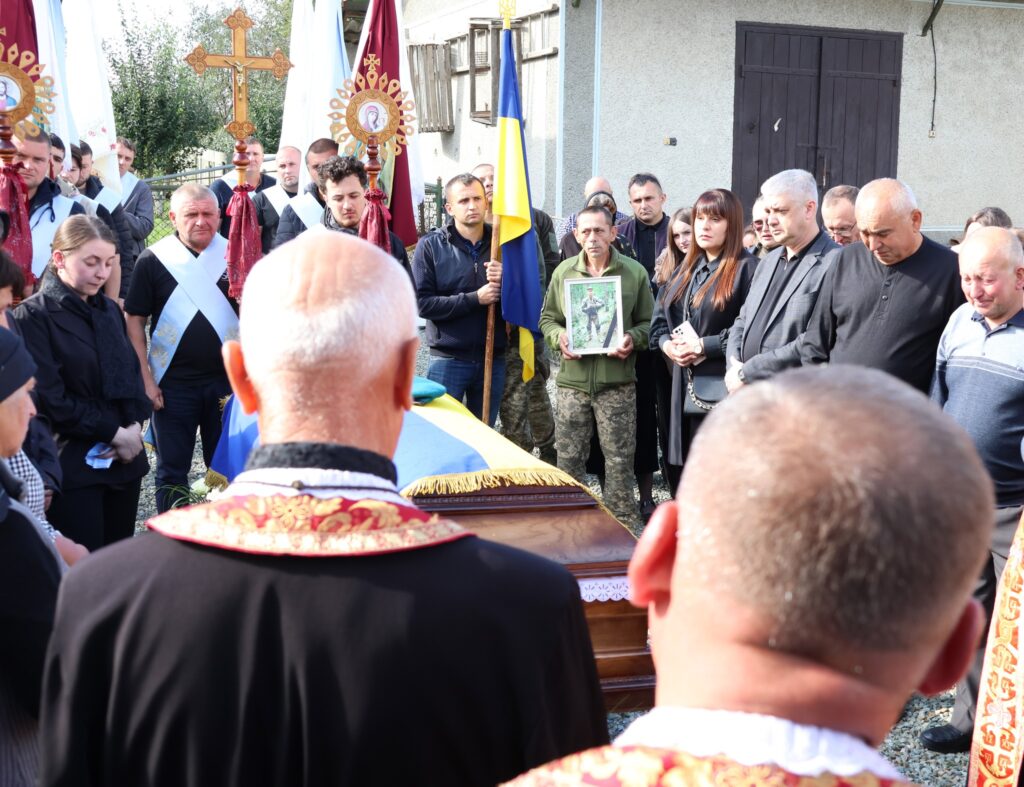 Люди на похороні під час церемонії прощання.