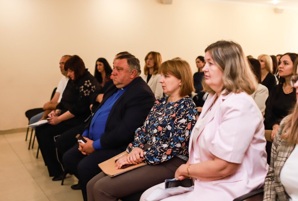 Учасники на діловій конференції, кімната зі світлими стінами.