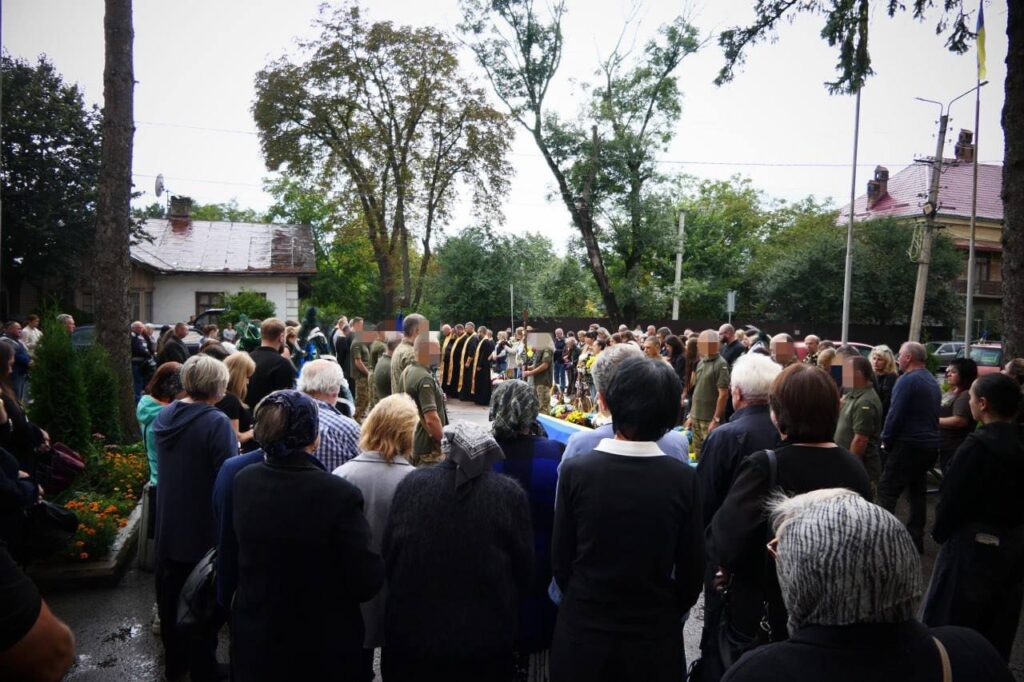 Мітинг людей на вулиці під деревами.