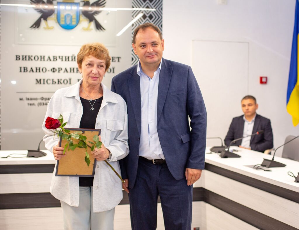 Жінка з квіткою і чоловік у офіційному одязі.