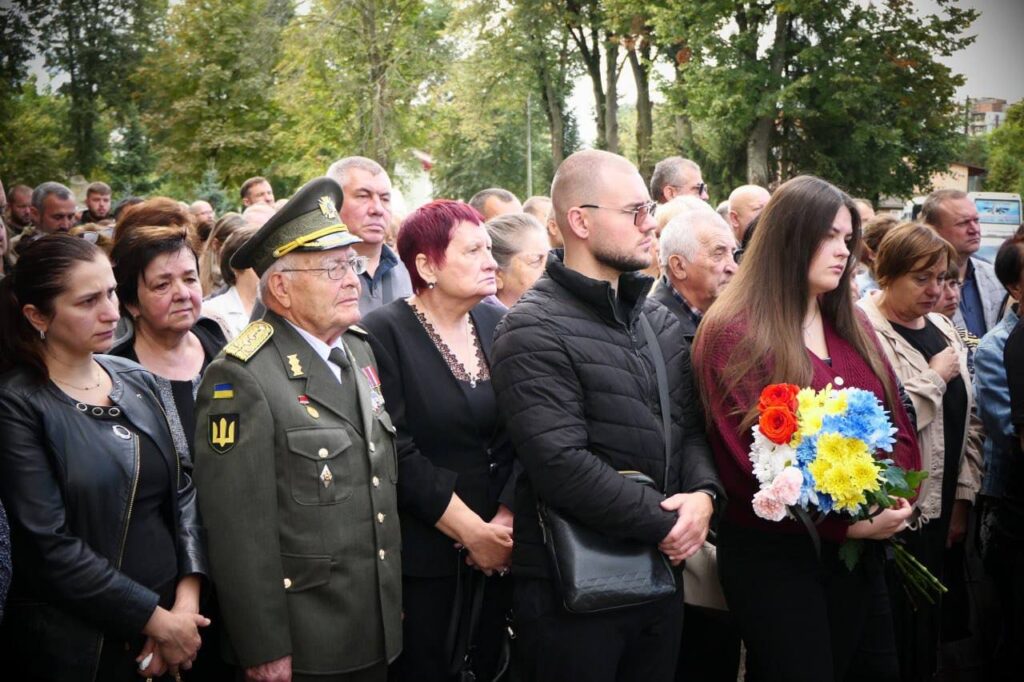 Люди на вуличному заході з квітами