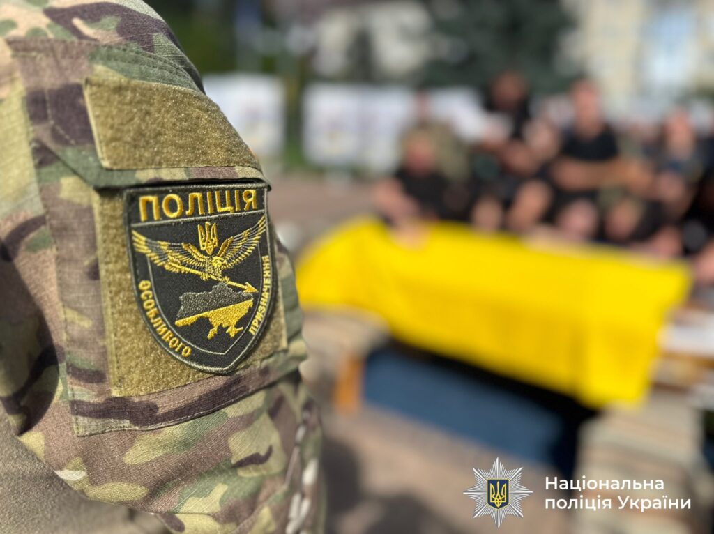 Поліцейський в формі біля прапора України