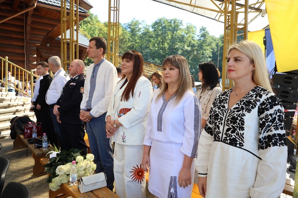 Люди стоять у традиційному одязі на заході