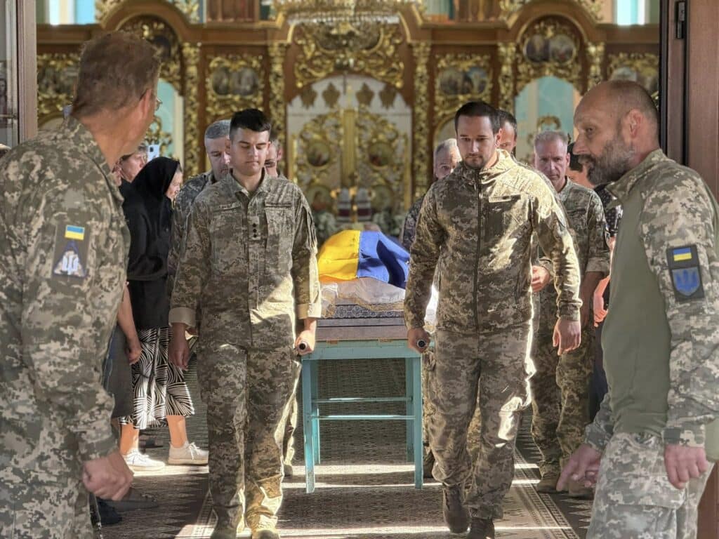 Українські військові несуть труну в церкві
