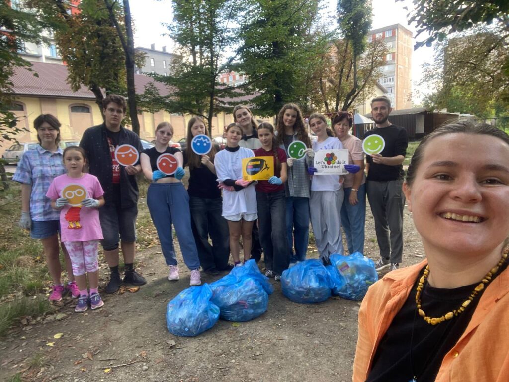 Група людей бере участь в екологічній акції на вулиці.