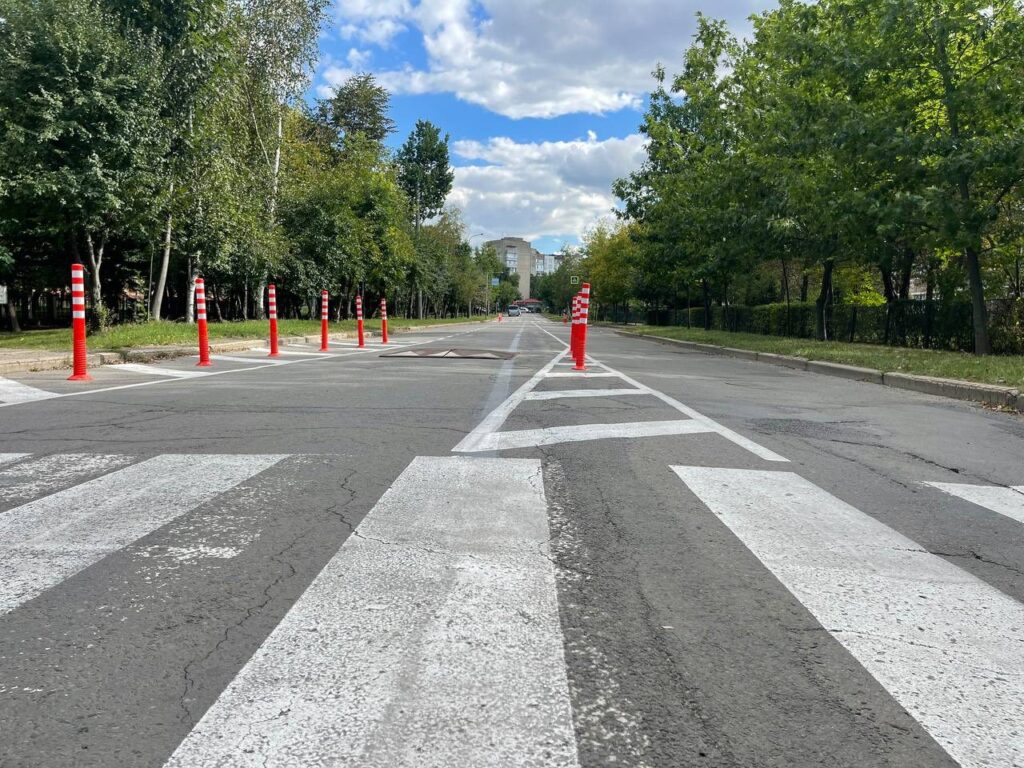 Порожня вулиця з червоними конусами та деревами