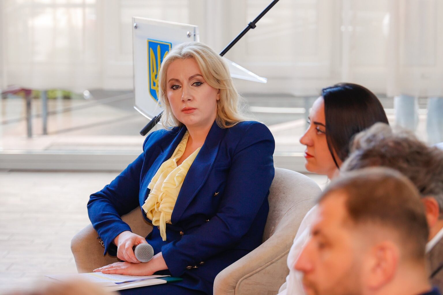 Жінка на конференції, тримає мікрофон