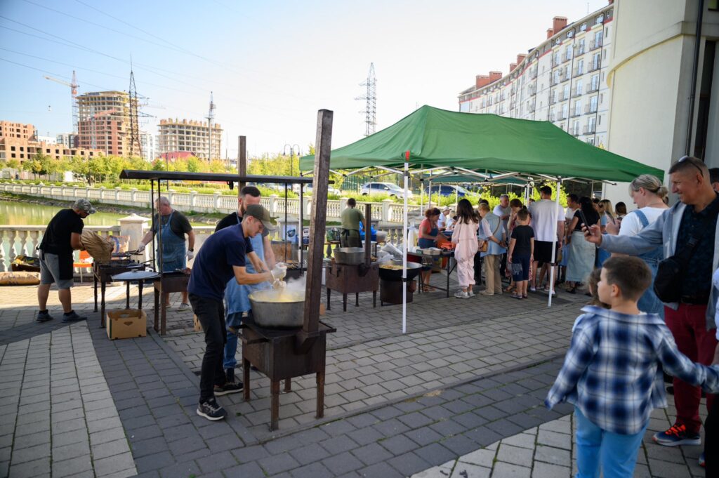 Люди готують страви на вулиці під наметами.
