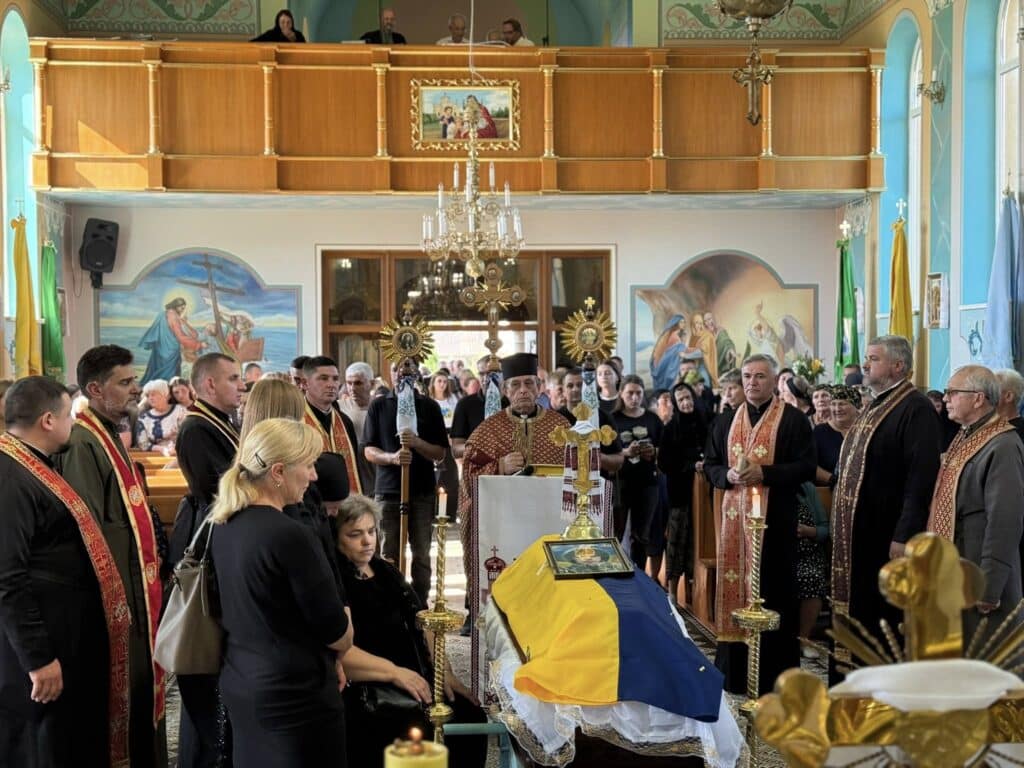 Церемонія вшанування пам'яті у церкві з прапором