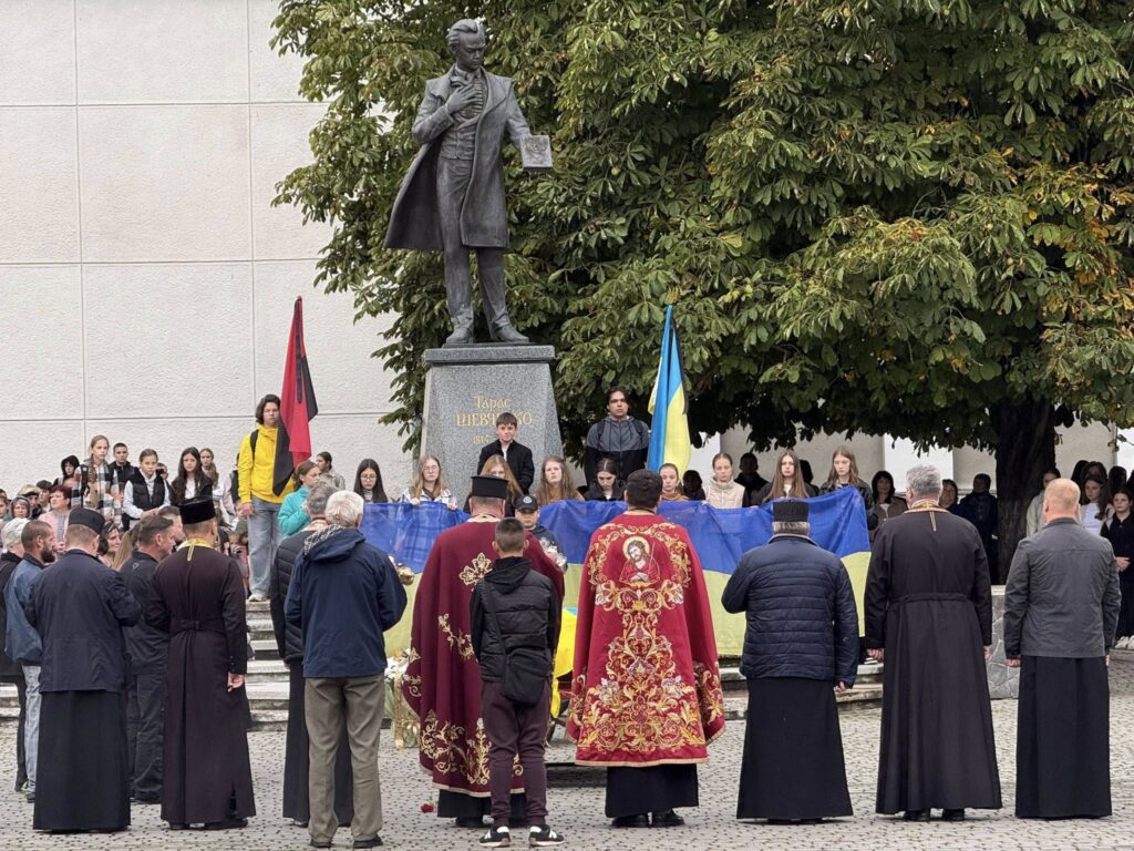 Захід біля пам'ятника з українським прапором та людьми