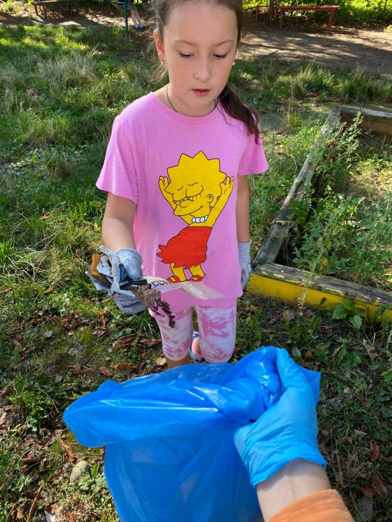 Дитина збирає сміття на природі