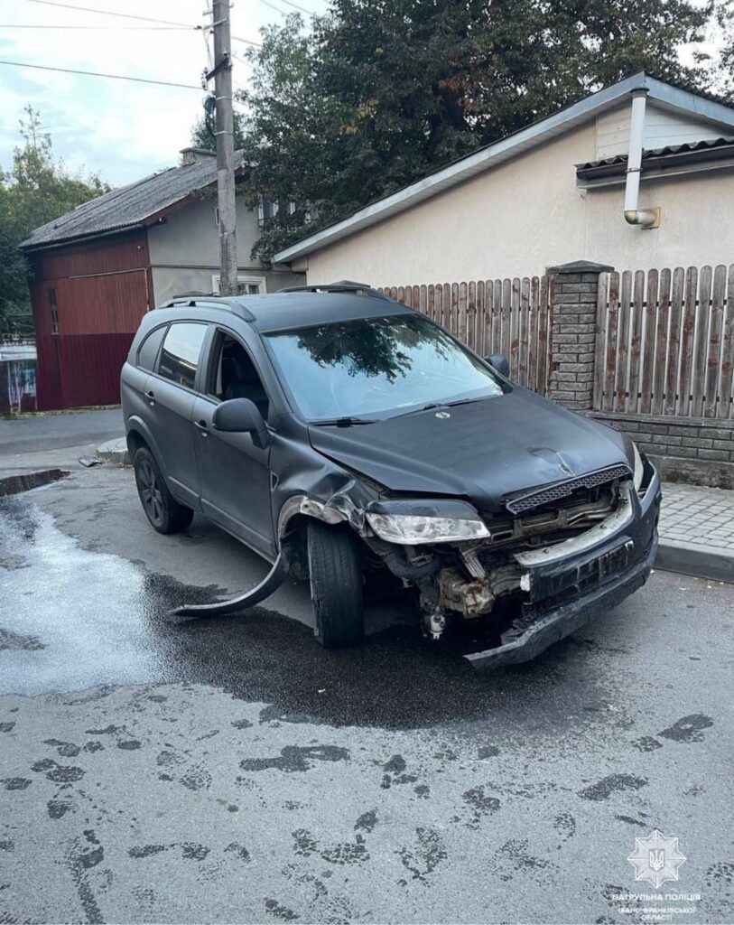 Чорний автомобіль з пошкодженнями після аварії на дорозі