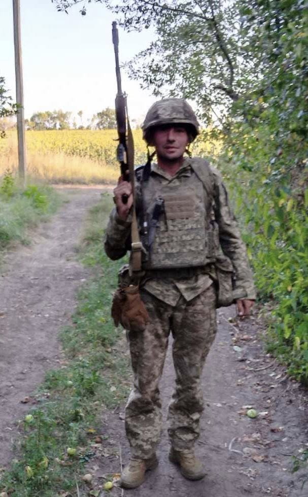 Український солдат на сільській стежці з автоматом