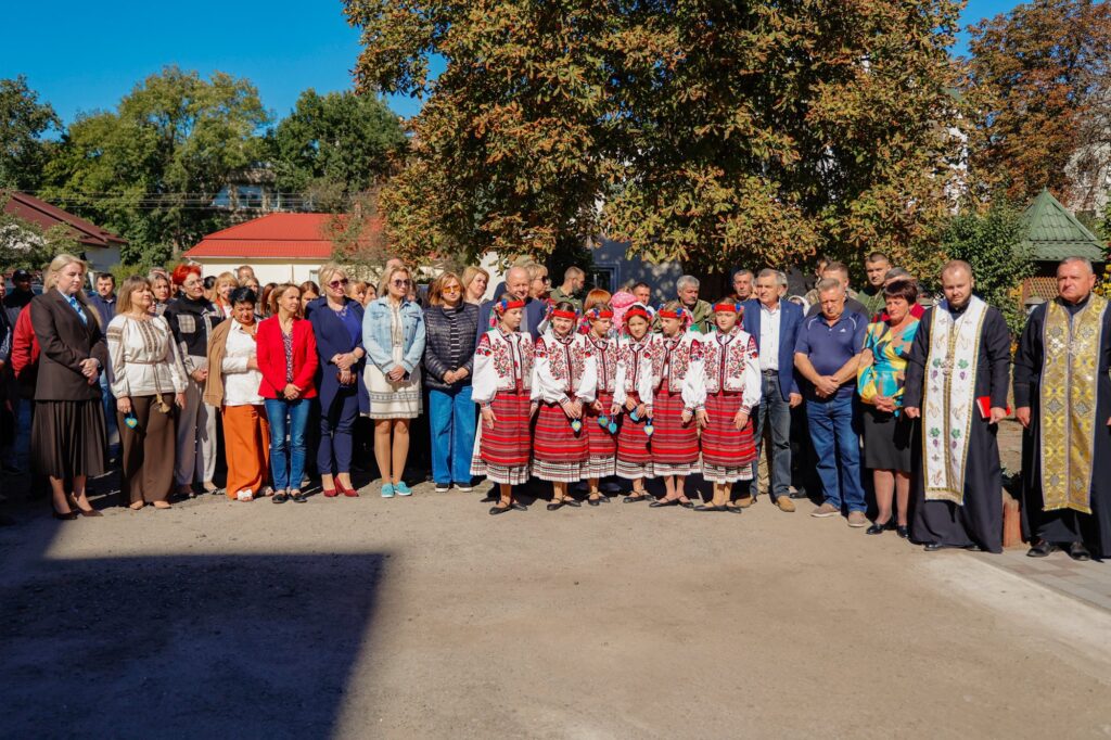 Група людей в традиційному українському одязі на вулиці.